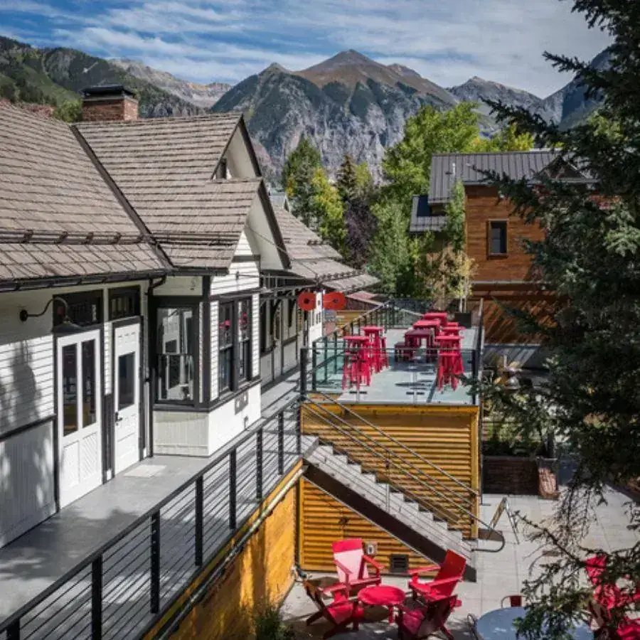 A Telluride community scene — red Adirondack chairs and patio against the Box Canyon mountains