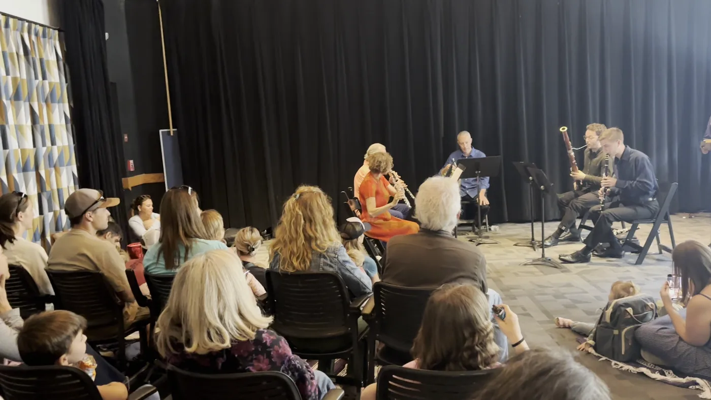A New York Philharmonic wind quintet performing at a family outreach event with kids and families seated close